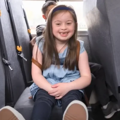 a smiling girl in a bus seat